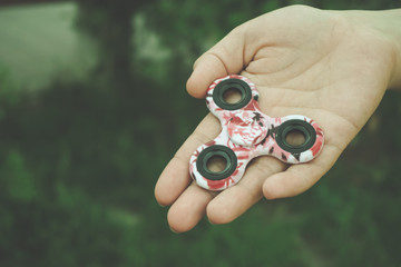 Girl hand holds and shows hand fidget spinner toy