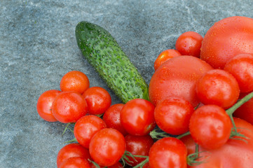 red tomatoes, cucumbers and dill on the board