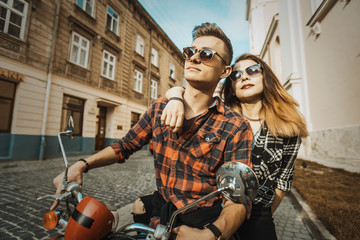 Fototapeta na wymiar Young attractive love hipster couple, girl and boy, with retro motorbike, sunny street