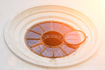 Round window the background of a white wall. Close-up. Toning.