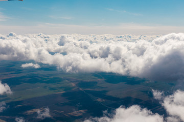 Fototapeta premium Above view of white clouds and lands with fields.