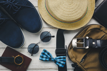 Top view accessories to travel with man clothing concept. bow tie,wallet on wooden background.watch,sunglasses,bag,hat and shoes on wood table.