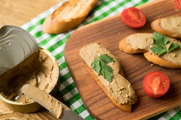 Liver pate on the bread on wooden tray.