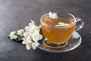 Jasmine tea with jasmine flowers on a dark  background.