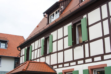 Traditional german village half-timbered house with wooden decoration and green shutters of the vindows, Walldorf, Germany.