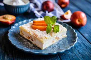 Dessert made of two puff pastry layers filled with mascarpone cream and nectarine