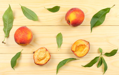 peach fruit with strawberry and green leaf on light wooden background. top view with copy space