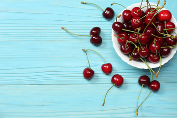 Naklejka na ściany i meble cherries in bowl on blue wooden background. Top view with copy space.