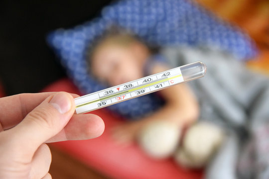 Termometr. Śpiące dziecko z gorączką.