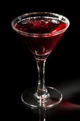 Martini glass with red cocktail of vodka, soda and grape juice