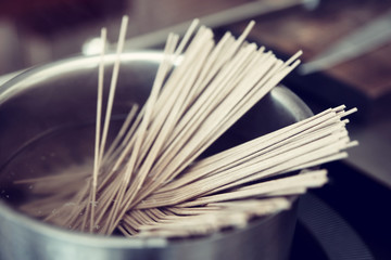Noodles being cooked on induction stove, toned
