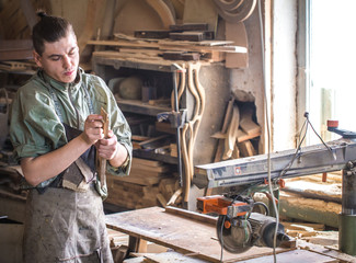 a man works on the machine with the wooden product