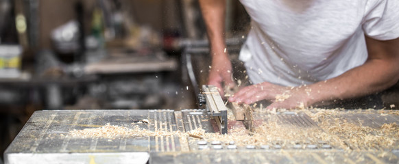a man working with wood product on the machine
