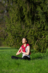 Meditating young beautiful woman on green ,field, grass, nature, fresh, forest, natural background