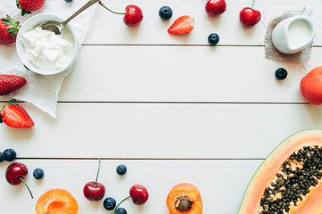 Naklejka na ściany i meble Summer fruits. Fresh juicy berries and papaya on the white wooden table, top view
