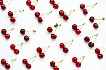 Cherries with petioles lined in rows on a white background. Pattern of cherries. Fruit Pattern