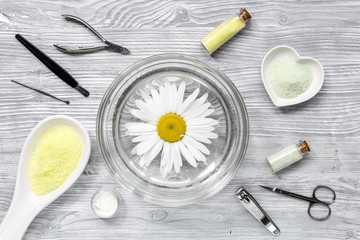 hands care set for manicure with chamomile on gray wooden background top view