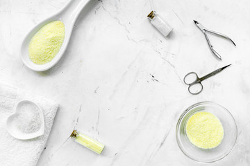 natural cosmetics with bowl of chamomiles and tools for manicure on white textural background top view space for text