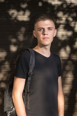 Teenage Boy looking at camera on background of Urban wall