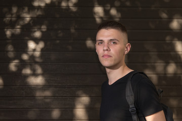 Teenage Boy looking at camera on background of Urban wall