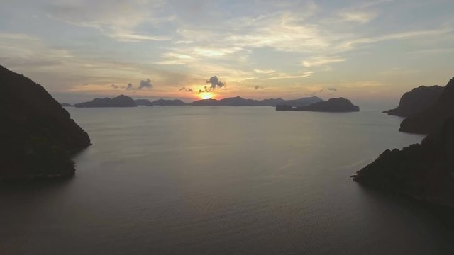 Tropical bay in El Nido sunset.Aerial view:tropical landscape.Sunset sky and mountains rocks of bay.Dreamy sunset among the rocks.Aerial video tropical island.Philippines,El Nido.4K video.Travel