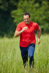Fototapeta premium Man trail running by the forest