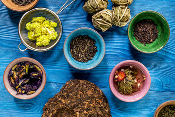Different kinds of herbal tea on blue background top view