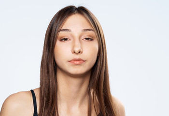 Obraz premium Serious woman with flowing hair, woman on a light background portrait