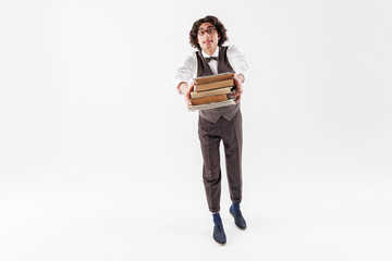 Excited young smart man holding heap of books