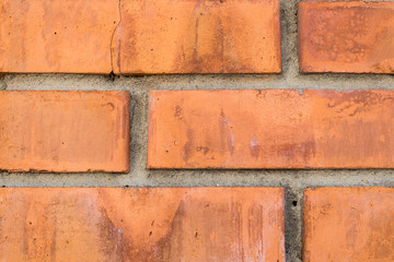 Brick red wall. Construction hand-made of bricks. Background of masonry construction.