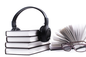 books with headphones and spectacles. Audio book concept