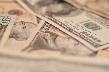 Hundred dollar banknotes close-up on a blurred background of other bills