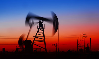 Pumping unit in the work, under the sunset of oilfield