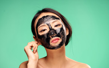 Woman in cosmetic mask, skin problem, facial treatment on green background portrait
