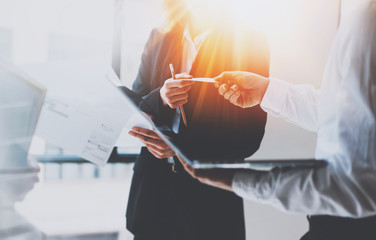 Group of businessmans on meeting.Business team at working process.Young woman giving business card to partner.Blurred background.Horizontal.Flares effect.