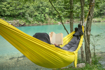 Man reading a book in hammock - nature beauty