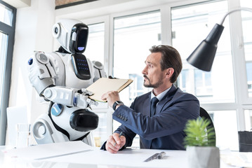 Concentrated confident mature man working with android