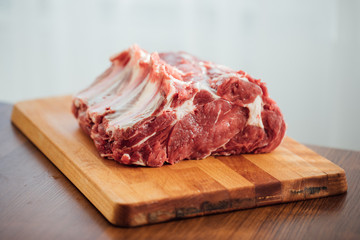 piece of raw beef meat on wooden board