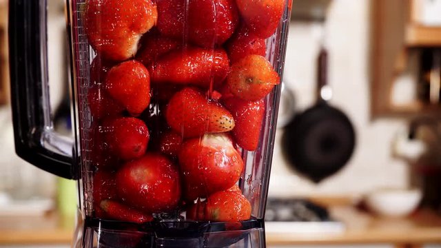 Making fresh strawberry fruit shake milkshake at home in blender high speed machine. Healthy eating, vegetarian food, diet concept. 4K ProRes HQ codec