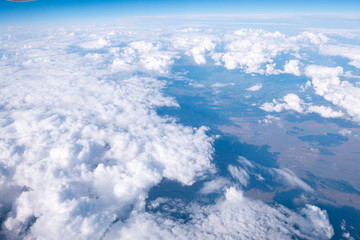 Fototapeta na wymiar Clouds and sky sunny day through airplane window