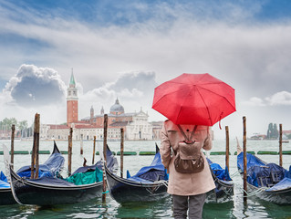 Fototapeta na wymiar Woman with a red umbrella looking at San Giorgio Maggiore church, Venice