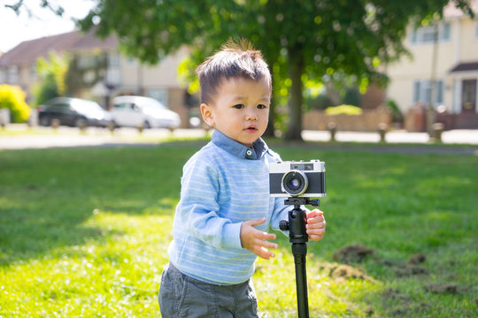 asian baby use a vintage camera