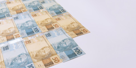 Obraz na płótnie Canvas Brazilian money background. Bills called Real, different values. Economy of Brazil concept image.