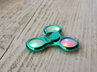 Popular fidget spinner toy on white wood background