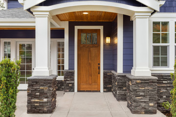 New Luxury Home Exterior Detail: New House Front Door and Covered Patio with Arch, Columns, and...