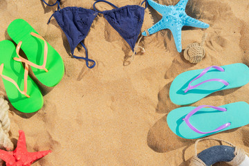 Fototapeta na wymiar Summer beach scene - frame on sand with sandals, copy space on sand