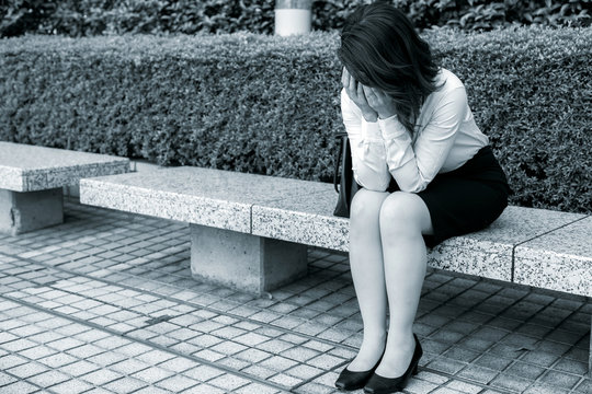 depressed business woman sitting on the bench.