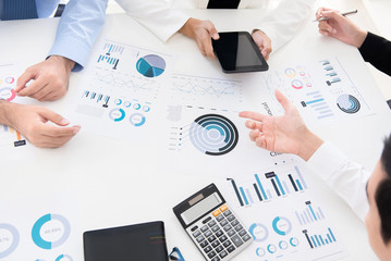 Business people discussing and analyzing financial graph documents