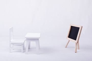 White chair and desk with a blackboard in classroom
