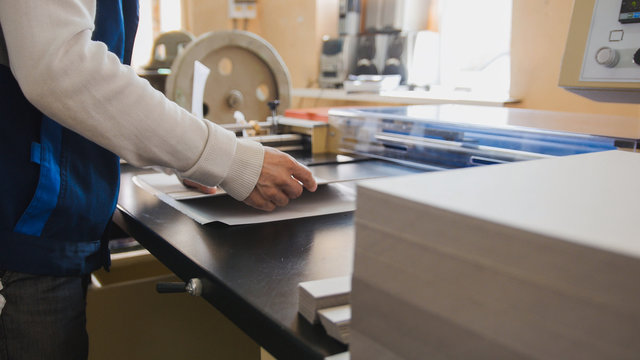 Print operator pulls printed sheet of paper